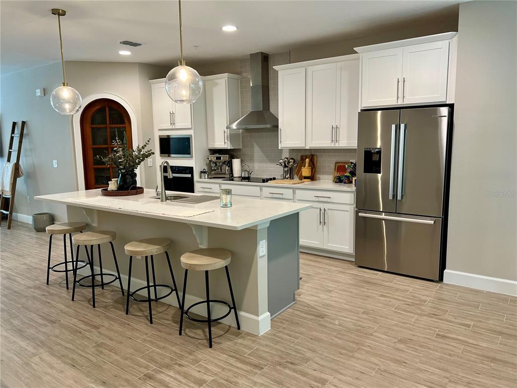 1266 Spotted Sandpiper Loop Winter Springs, FL 32708 - Photo 6 of 21 a kitchen with stainless steel appliances granite countertop a refrigerator a stove a sink cabinets and wooden floor