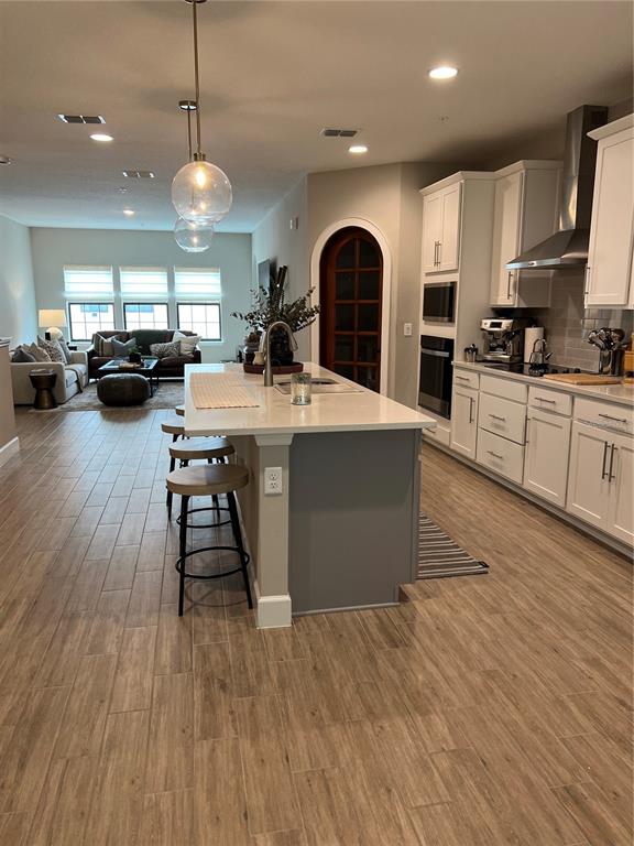 1266 Spotted Sandpiper Loop Winter Springs, FL 32708 - Photo 7 of 21 a open kitchen with stainless steel appliances granite countertop a stove a refrigerator a kitchen island with couches chairs and wooden floor