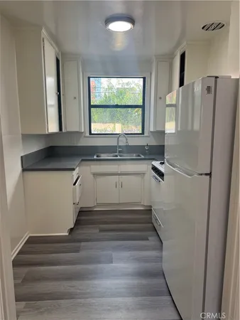 a kitchen with granite countertop a refrigerator and a sink