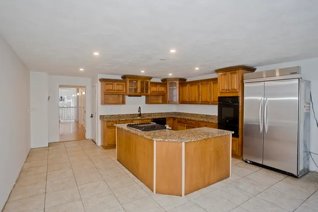 a kitchen with kitchen island granite countertop a stove top oven