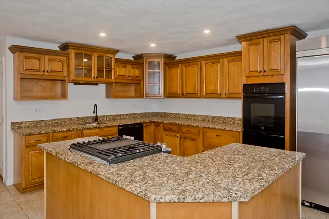a kitchen with stainless steel appliances granite countertop a sink stove and cabinets