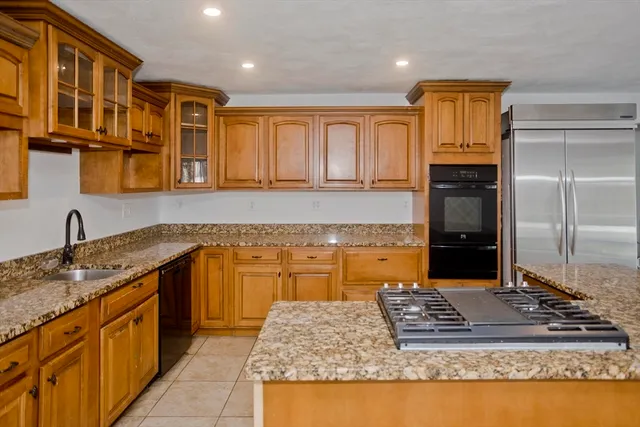a kitchen with granite countertop a stove top oven and cabinets