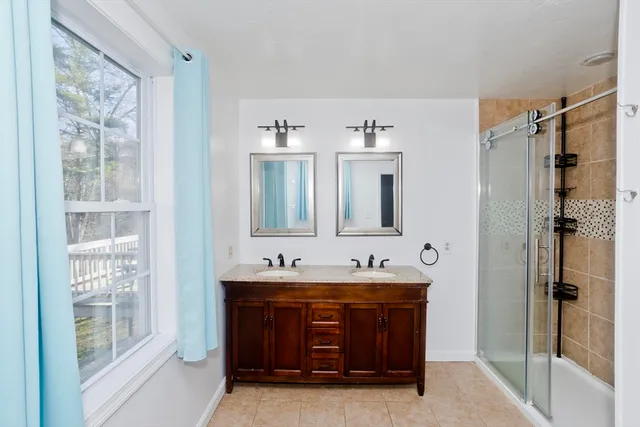 a bathroom with a granite countertop sink mirror and shower