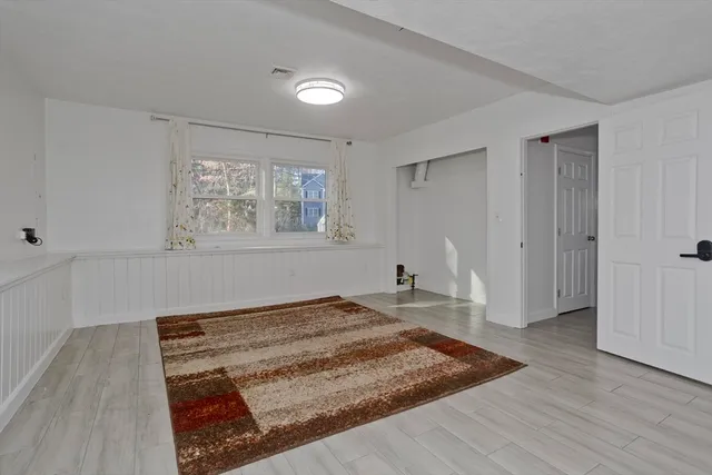 a view of a room with wooden floor and ceiling fan