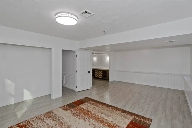 a hallway with wooden floor windows and a chandelier