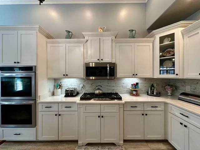 a very nice looking kitchen with granite countertop a sink cabinets and wooden floor