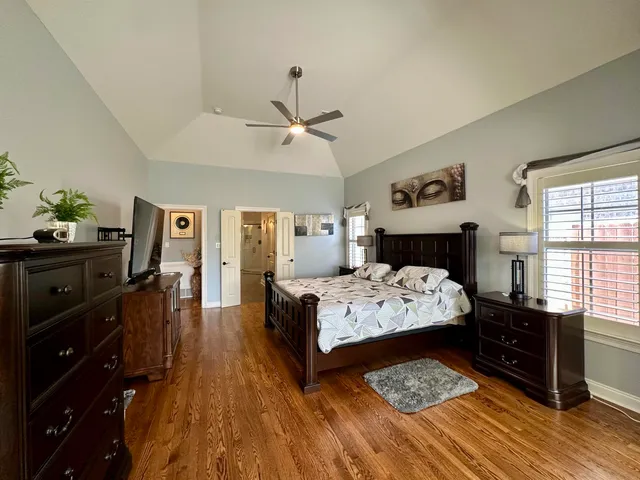 a spacious bedroom with a balcony a bed and a large window