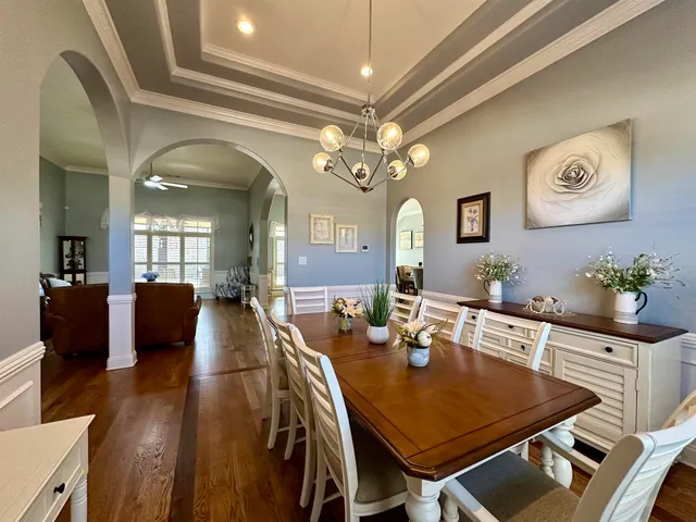 a view of a dining room with furniture and a chandelier