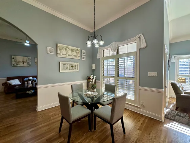 a dining room with furniture a chandelier and wooden floor
