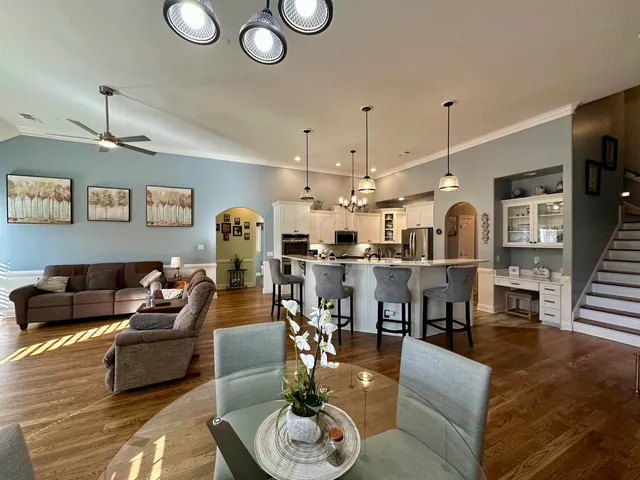 a living room with furniture kitchen view and a chandelier