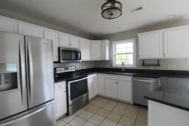 a kitchen with cabinets stainless steel appliances and a counter space