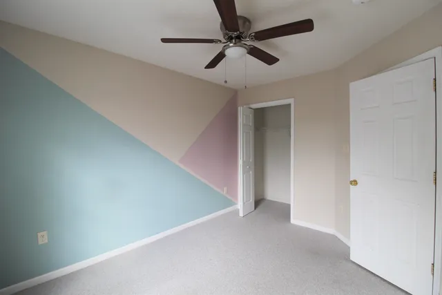 a view of a hallway with a ceiling fan