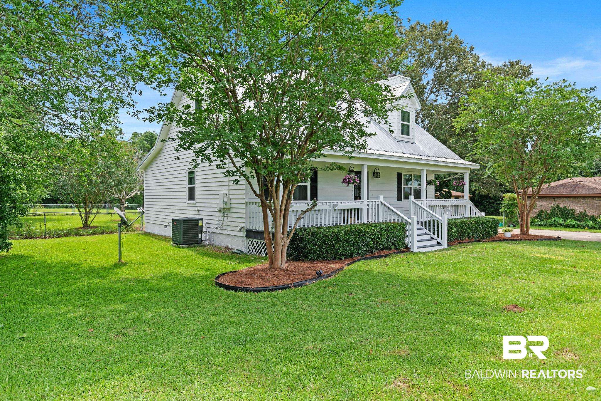 22810 High Ridge Road Fairhope, AL 36532 - Photo 13 of 78 White siding residence featuring a metal roof, dormer window, and covered front porch with white railing