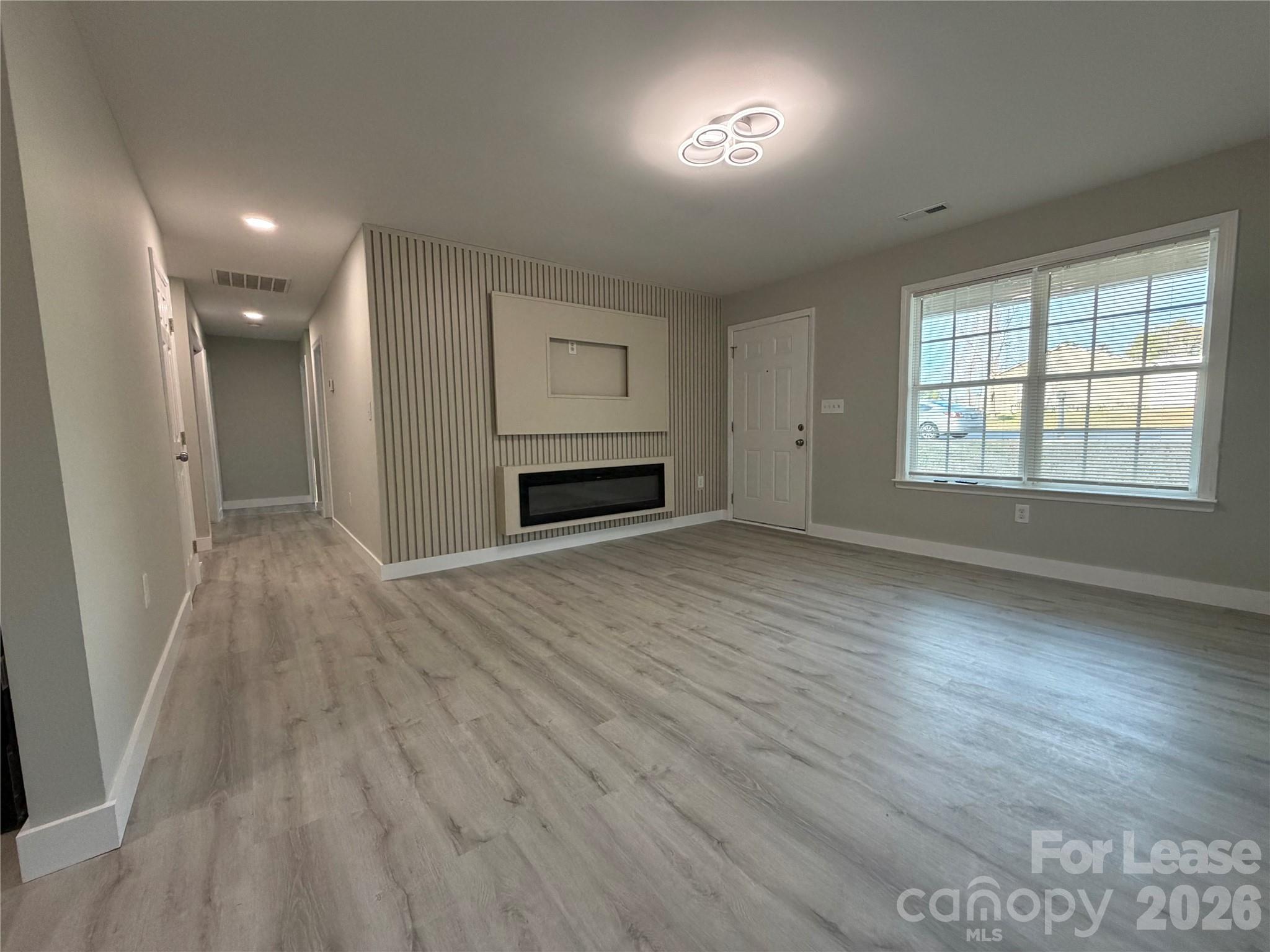 3134 Rainbow Ridge Drive Matthews, NC 28105 - Photo 1 of 12 an empty room with wooden floor and windows