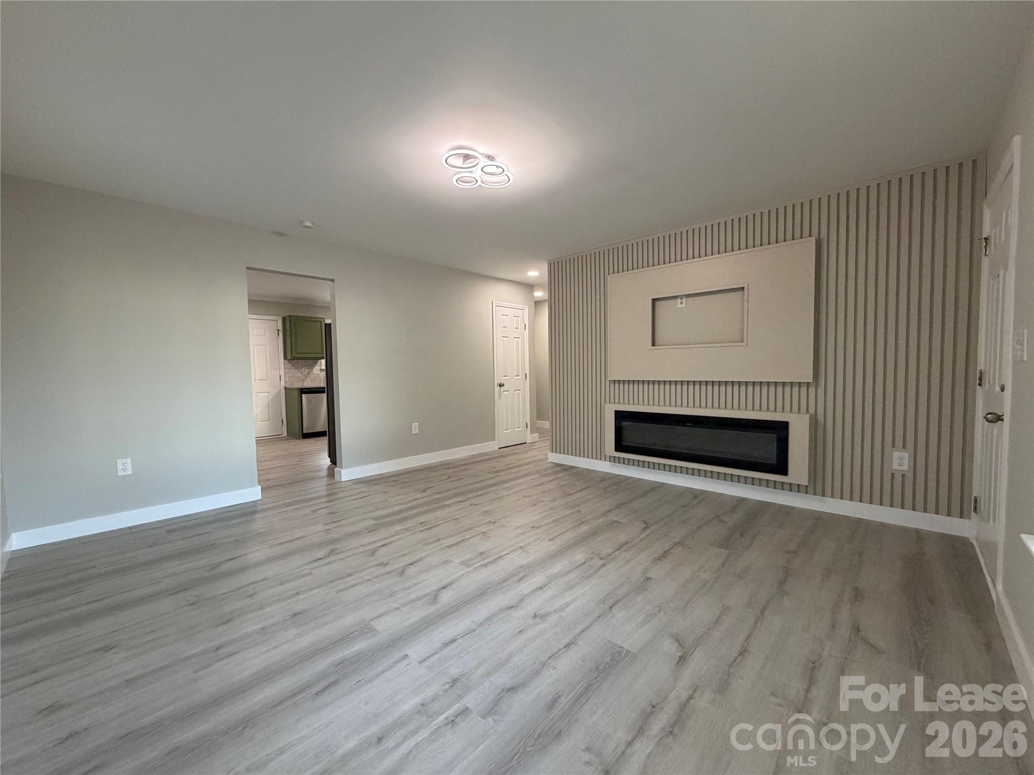 3134 Rainbow Ridge Drive Matthews, NC 28105 - Photo 2 of 12 a view of empty room with wooden floor and fireplace
