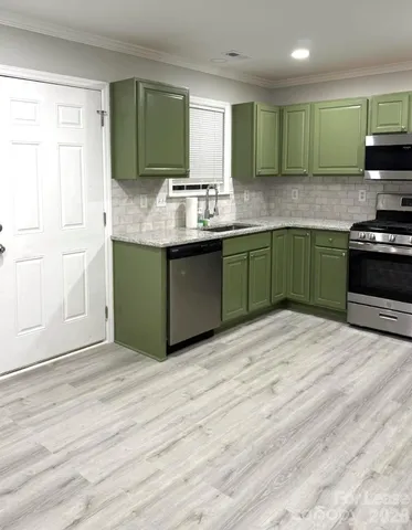 a kitchen with granite countertop a sink cabinets and stainless steel appliances