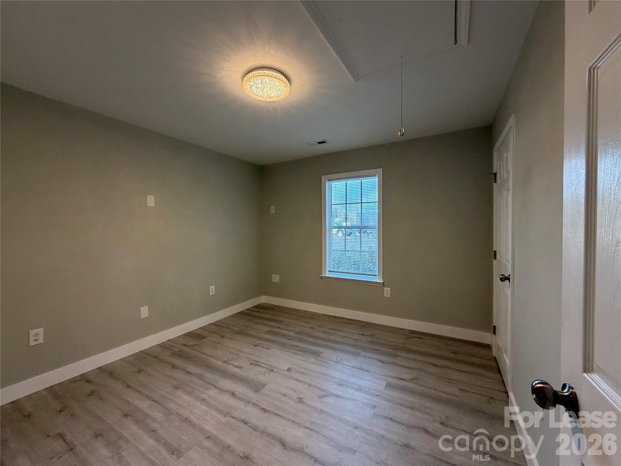 3134 Rainbow Ridge Drive Matthews, NC 28105 - Photo 9 of 12 an empty room with wooden floor and windows