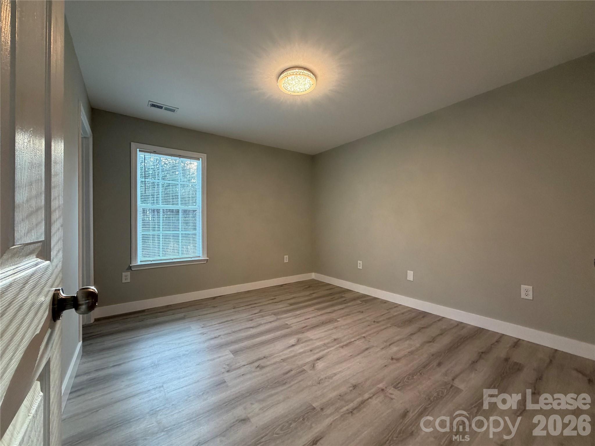 3134 Rainbow Ridge Drive Matthews, NC 28105 - Photo 10 of 12 an empty room with wooden floor and windows