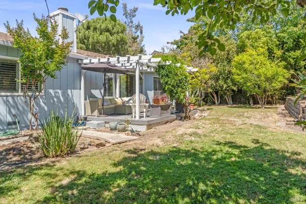 a view of a house with backyard and sitting area