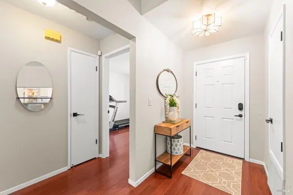 a view of a hallway with entryway wooden floor and front door