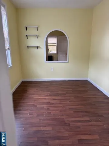 a view of a room with wooden floors and white walls