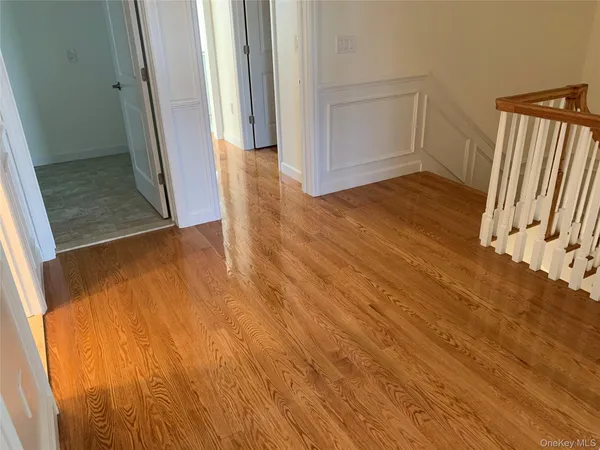 an empty room with wooden floor and entrance