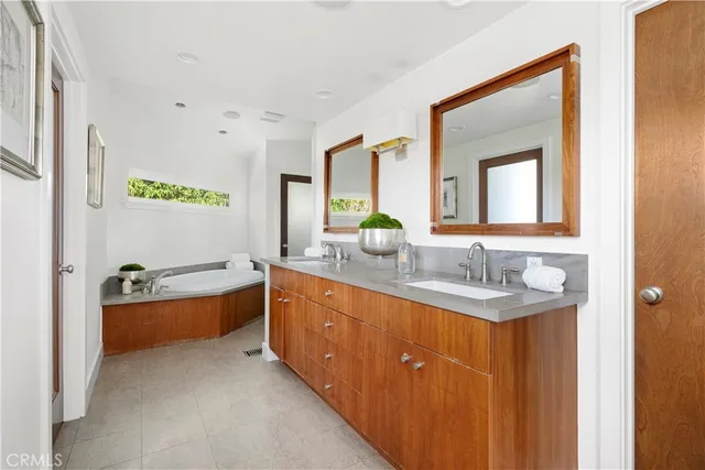 a bathroom with a tub double sink and mirror