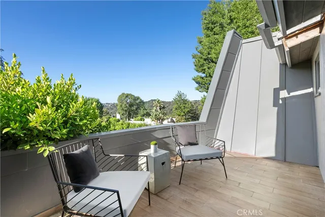 a balcony with wooden floor and outdoor seating