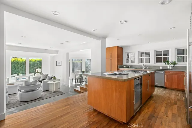 a large kitchen with stainless steel appliances a stove and wooden floor