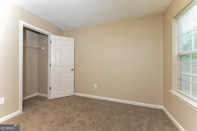 an empty room with windows and closet