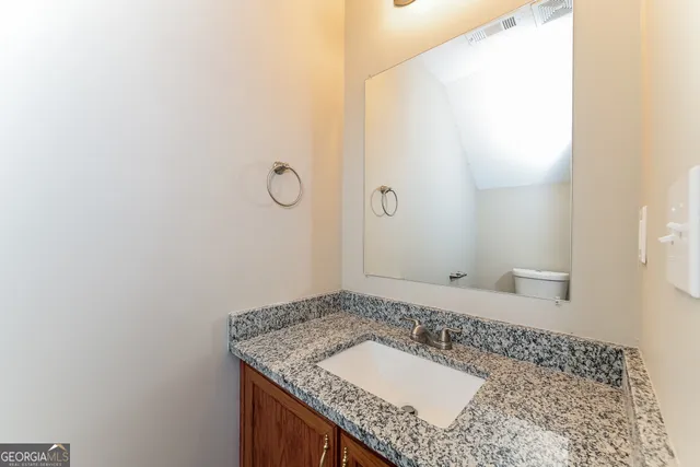 a bathroom with a granite countertop sink and a mirror