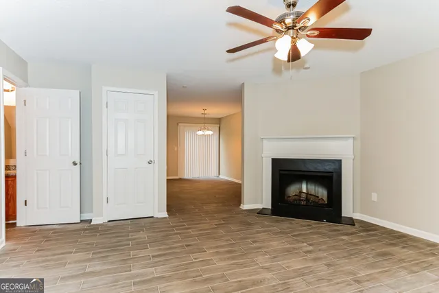 a view of a livingroom with a fireplace a ceiling fan and a fireplace