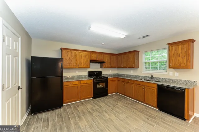 a kitchen with granite countertop stainless steel appliances and wooden cabinets