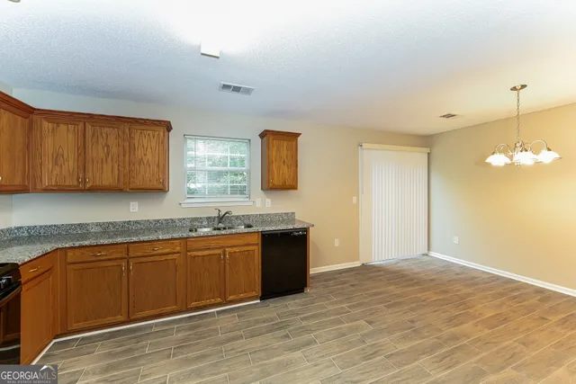 a view of a kitchen with granite countertop cabinets and wooden floor