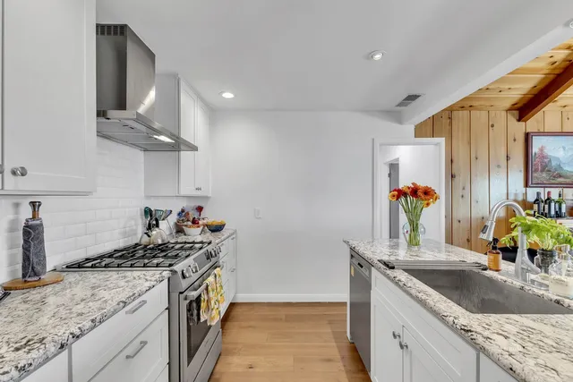 a bathroom with a sink a toilet a mirror a vanity and bathtub