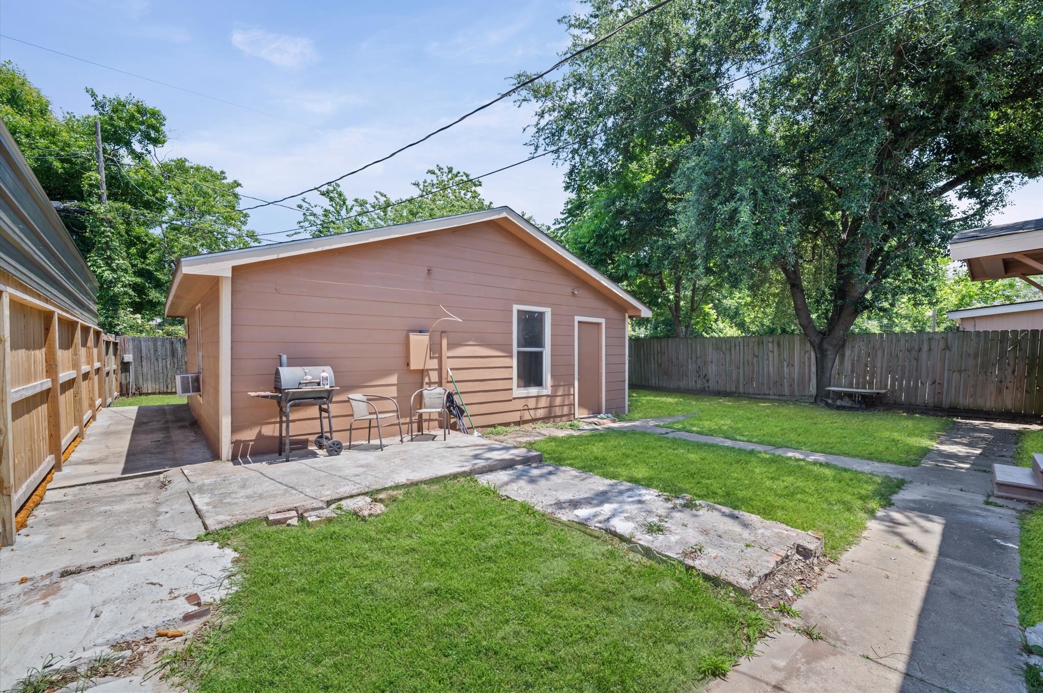 10621 Lane Street Houston, TX 77029 - Photo 20 of 29 a view of a backyard with table and chairs wooden fence and plants