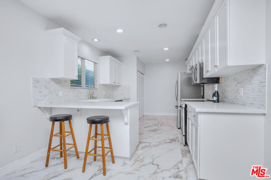 3701 Tilden Avenue Los Angeles, CA 90034 - Photo 9 of 29 a kitchen with stainless steel appliances granite countertop a sink and a refrigerator
