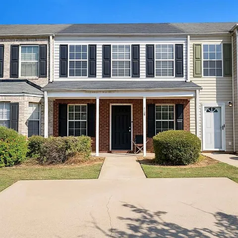 front view of a brick house with a yard