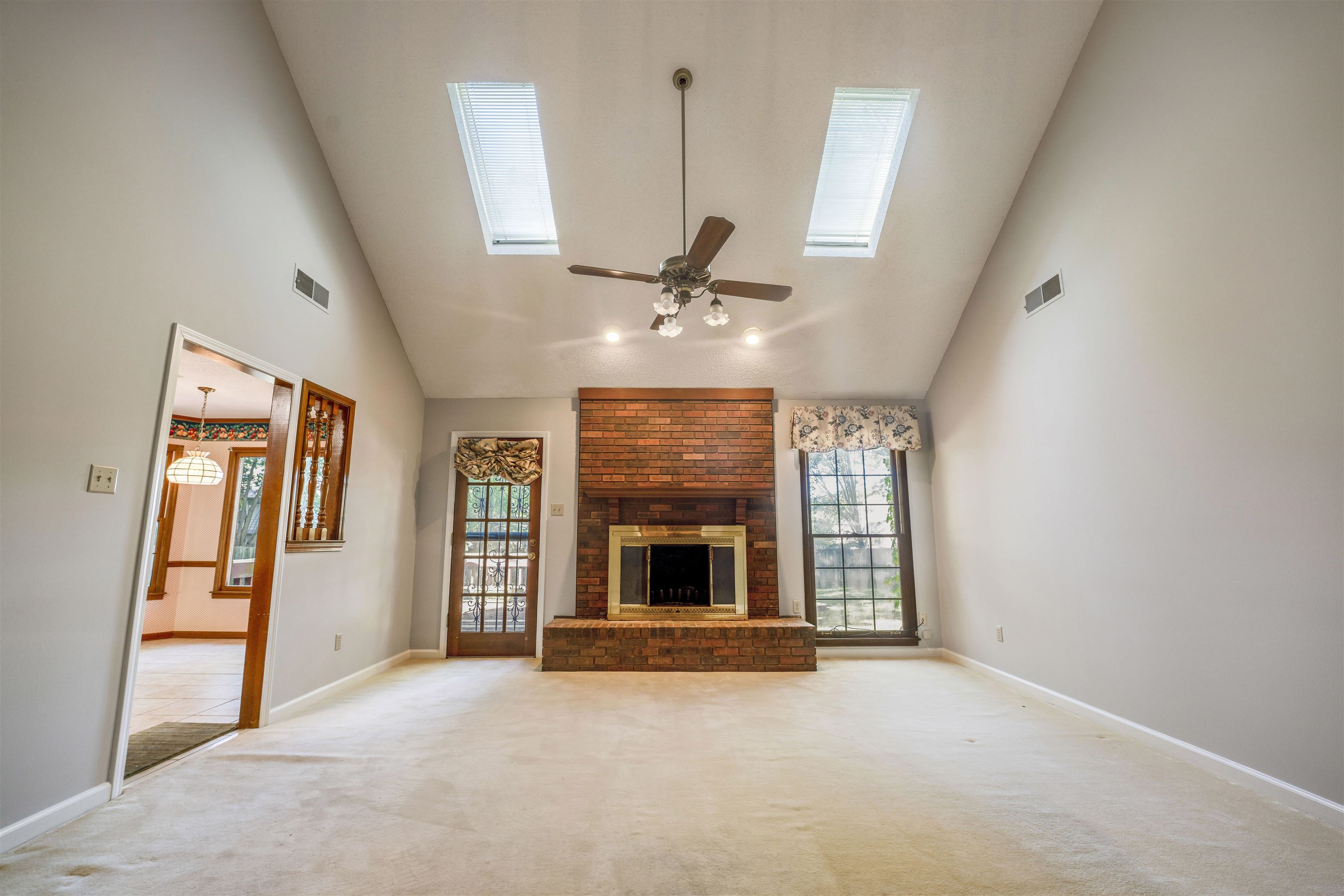 8497 Bazemore Road Memphis, TN 38018 - Photo 8 of 16 wooden floor fireplace and windows in an empty room