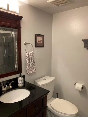 a bathroom with a sink a toilet a mirror and vanity