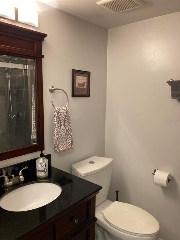 646 Midway Drive, Unit A Ocala, FL 34472 - Photo 8 of 15 a bathroom with a sink a toilet a mirror and vanity
