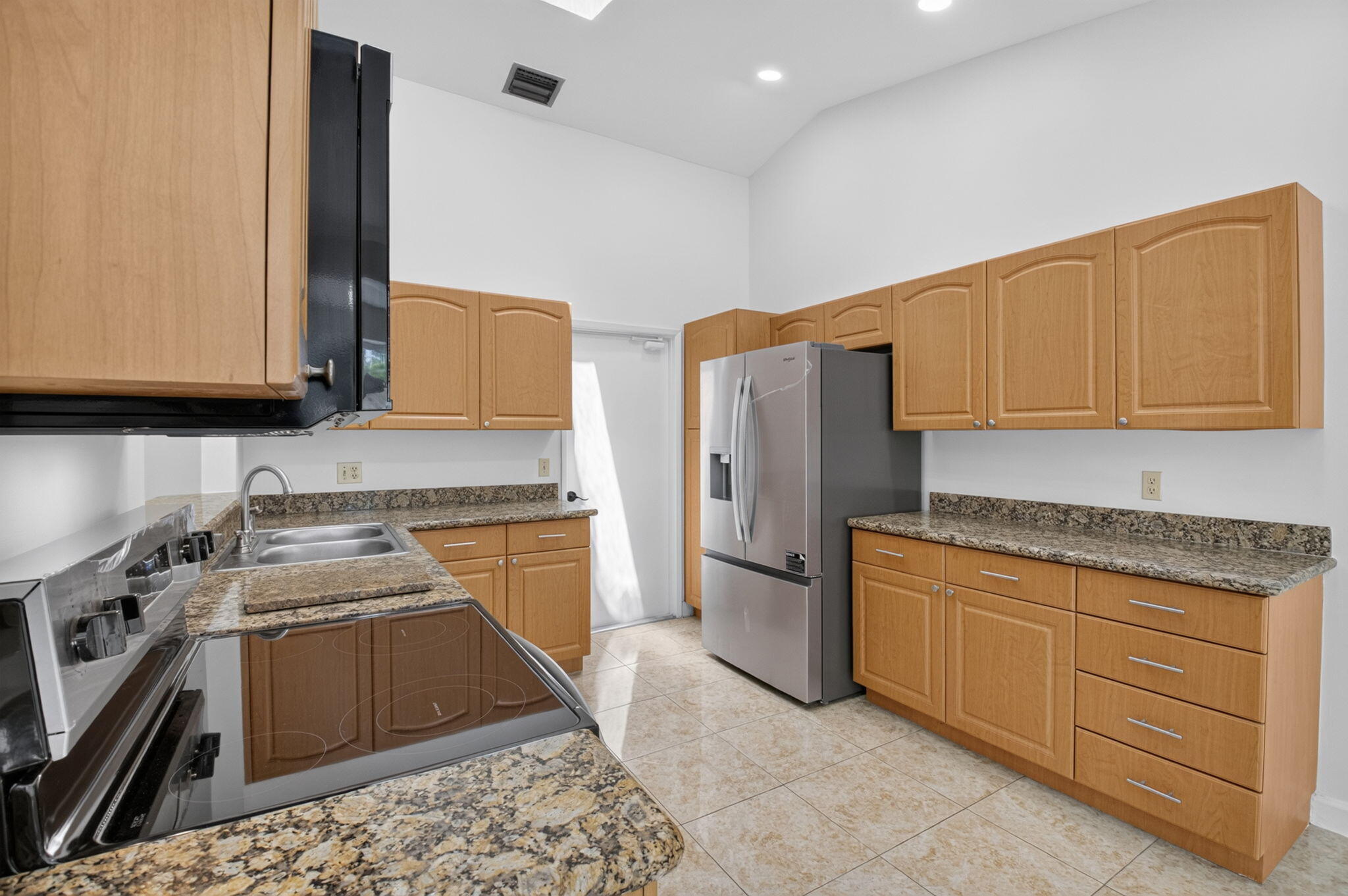 21070 Woodspring Avenue Boca Raton, FL 33428 - Photo 9 of 30 a kitchen with stainless steel appliances granite countertop a stove a sink and a refrigerator