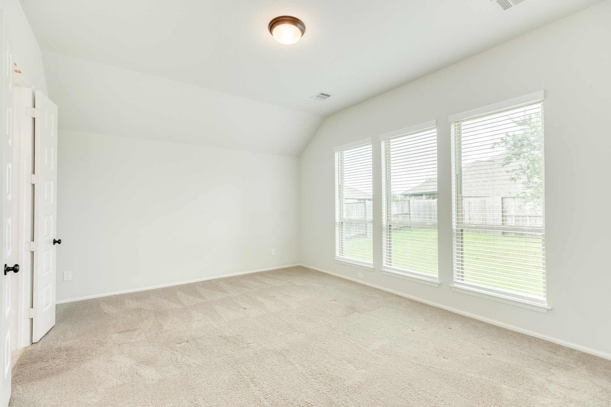 10115 Stride Court Rosharon, TX 77583 - Photo 13 of 40 Primary bedroom featuring an expansive layout with floor-to-ceiling oversized windows that provide scenic views of the backyard and pristine, like-new carpeting throughout.
