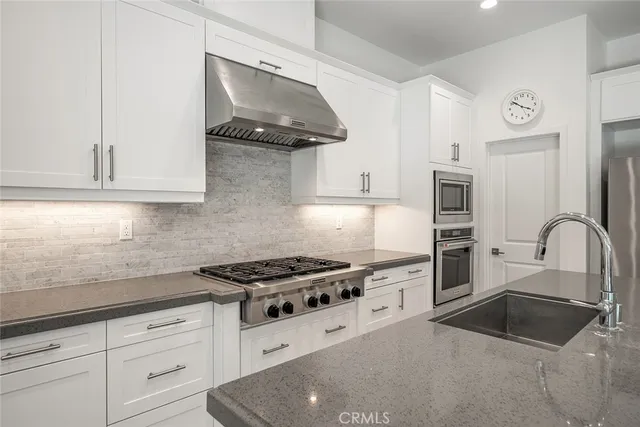 a kitchen with stainless steel appliances granite countertop a sink stove and cabinets