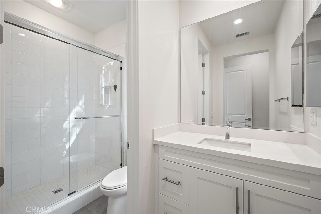 77 English Saddle Irvine, CA 92602 - Photo 19 of 35 a bathroom with a shower sink vanity mirror and toilet