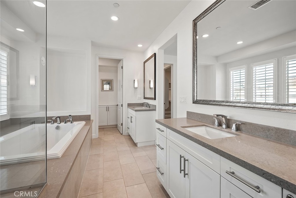 77 English Saddle Irvine, CA 92602 - Photo 26 of 35 a large white bathroom with a granite countertop double vanity sink a mirror and a bathtub