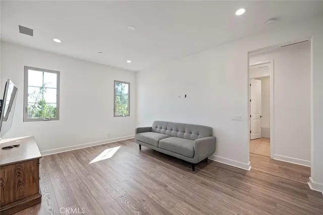 a bed sitting in a spacious bedroom next to a window
