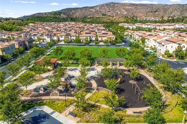 an aerial view of residential houses with outdoor space and trees
