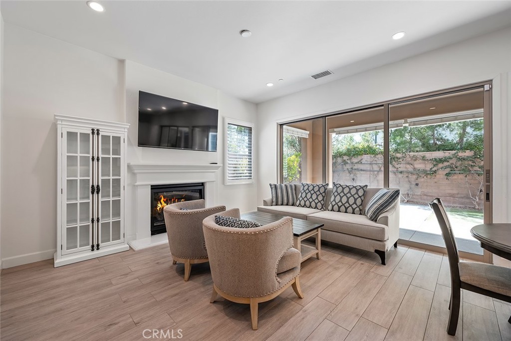 77 English Saddle Irvine, CA 92602 - Photo 9 of 35 a living room with furniture a fireplace and a floor to ceiling window