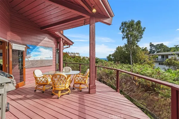 a roof deck with table and chairs and wooden floor